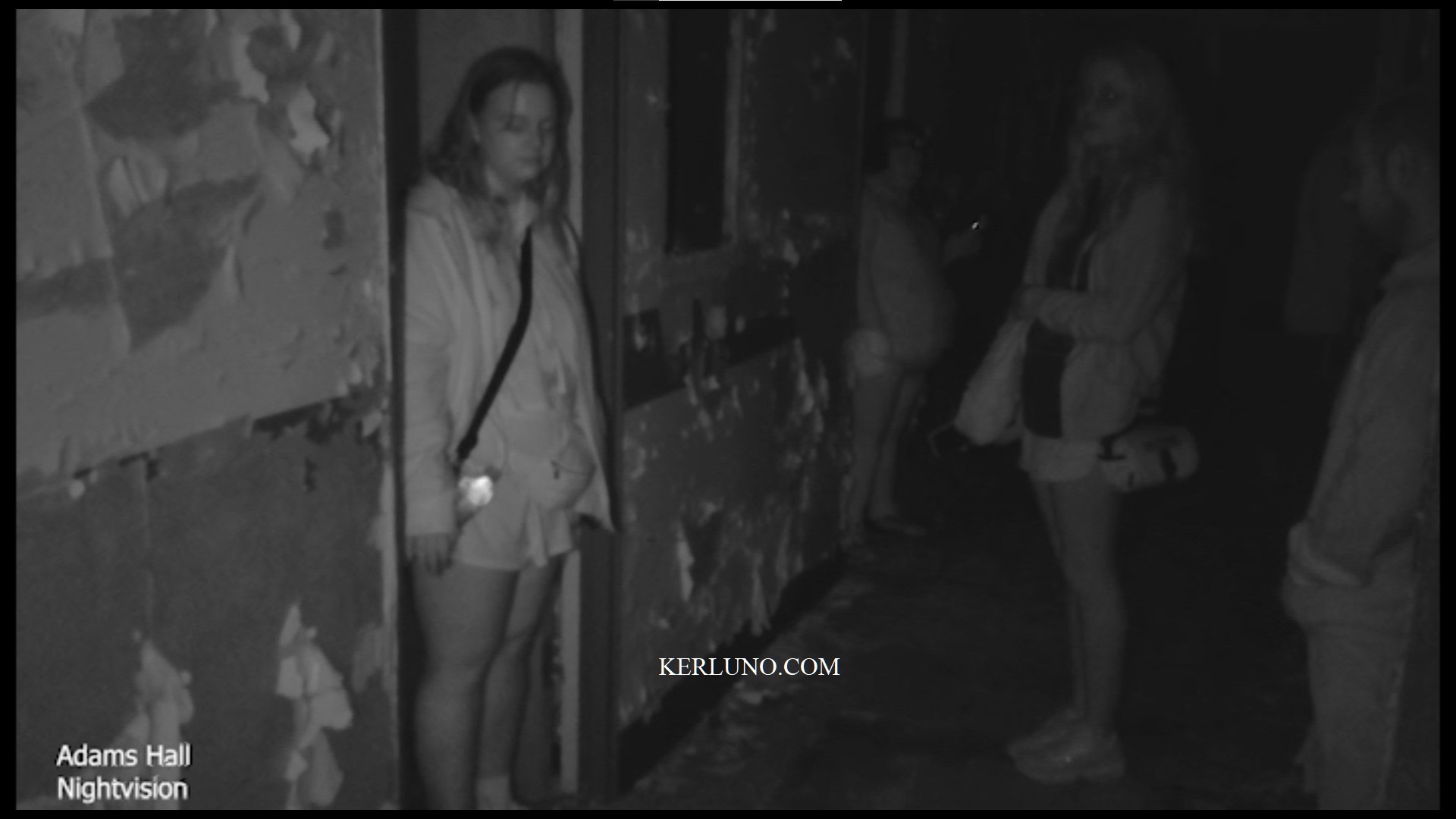 Two women standing in hallway, with blurry orb in the middle